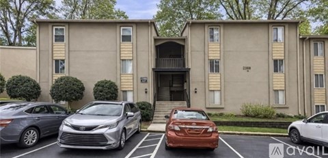 A row of cars are parked in front of a building with the word "AVAILABLE" on the front.