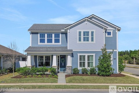 A two-story house with a front porch and a small front yard.