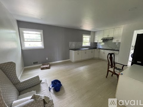 A living room with a grey couch and a blue bag on the floor.