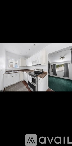 A modern kitchen with white cabinets and a black countertop.