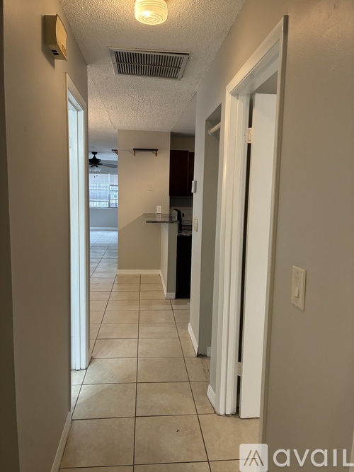 A long hallway with a white door on the right.