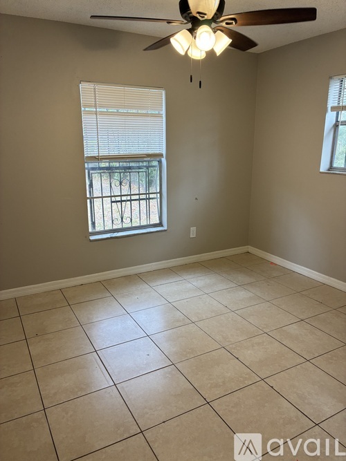 A room with a ceiling fan and tiled flooring.