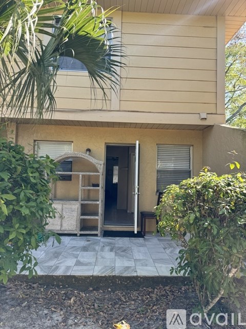 A house with a beige exterior and a tiled walkway leading to the front door.