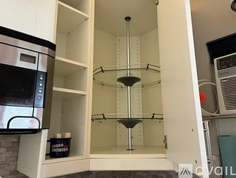 A kitchen with a white oven and a white cabinet with a black handle.