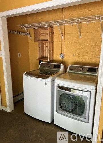 Two white ovens are in a room with yellow walls.