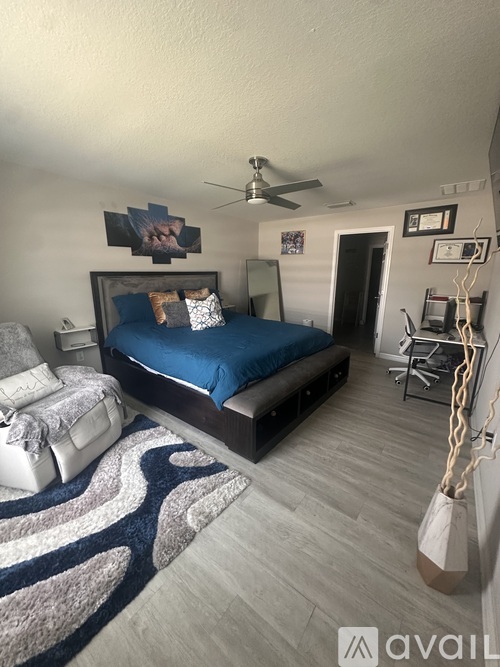 A bedroom with a bed, a ceiling fan, and a rug.