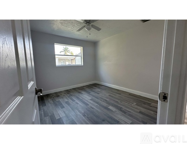 A room with a ceiling fan and a window.