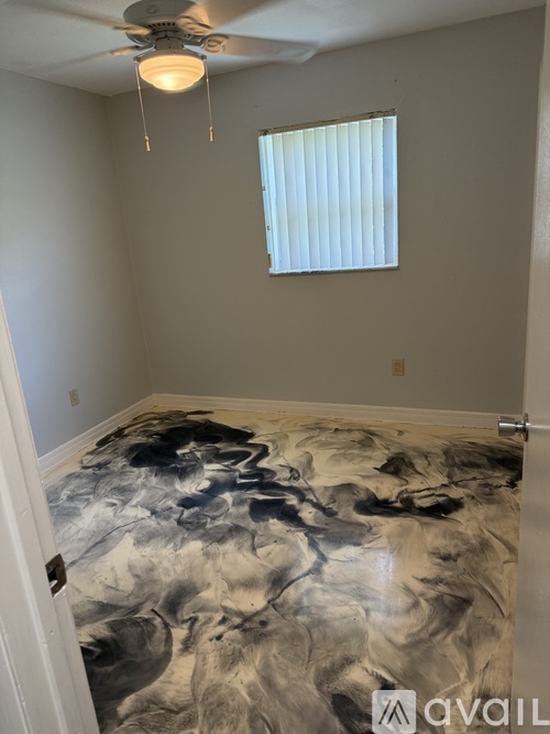 A room with a ceiling fan and a window with blinds.