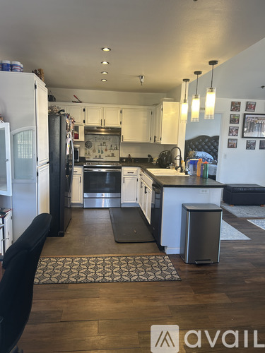 A kitchen with a white fridge and a black chair.