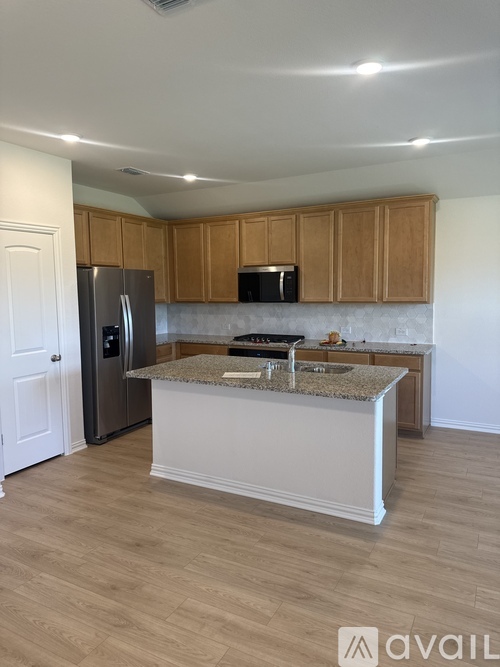 A kitchen with a granite countertop and wooden cabinets.