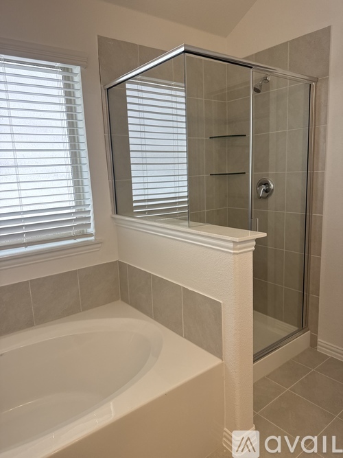 A bathroom with a white tub and a glass shower door.