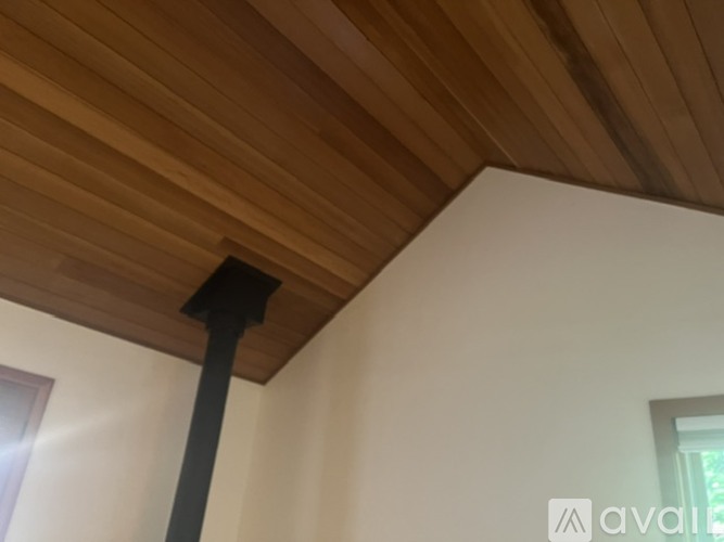 A wooden beam on a white wall.