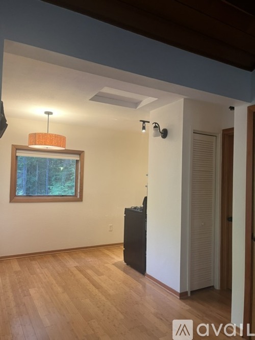 A room with a wooden floor and a painting on the wall.
