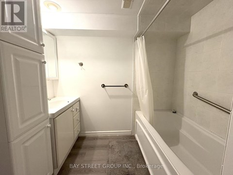 A white bathroom with a towel rack and a shower curtain.