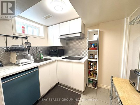 A kitchen with white cabinets and a blue dishwasher.