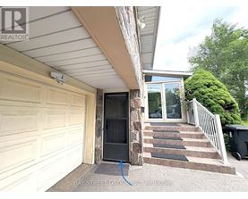 A house with a garage door and steps leading to a glass door entrance.