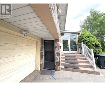 A house with a garage door and steps leading to a glass door entrance.