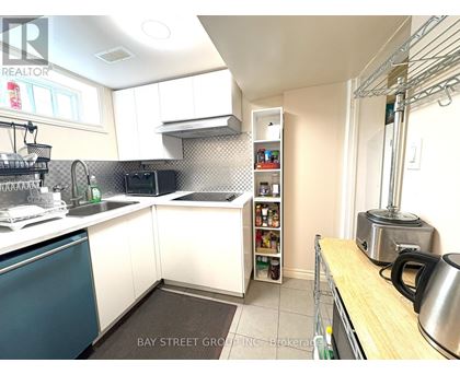 A kitchen with white cabinets and a blue dishwasher.