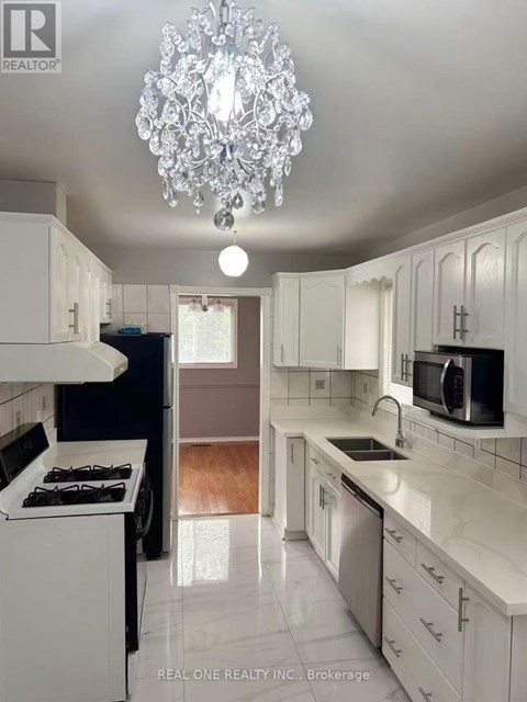 A white kitchen with a chandelier hanging from the ceiling.