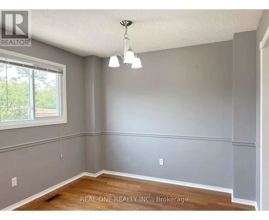 A room with a window and a wooden floor.