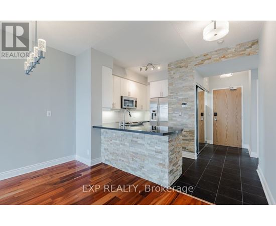 A kitchen with a stone counter and wooden floors.