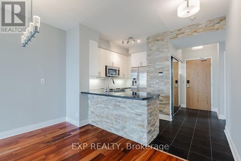 A kitchen with a stone counter and wooden floors.
