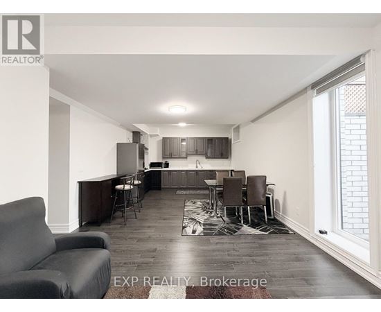 A living room with a grey couch and a wooden floor.