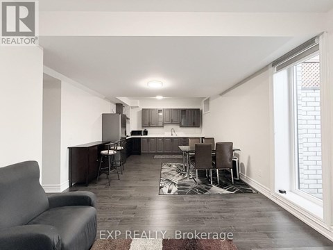 A living room with a grey couch and a wooden floor.