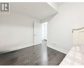 A bedroom with a bed on the right side and a doorway leading to another room.