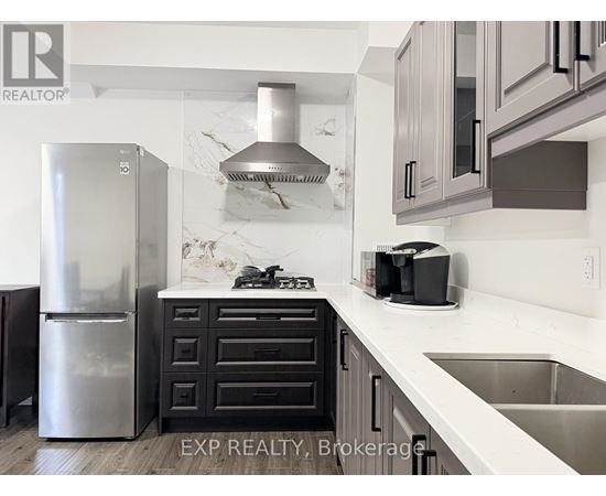 A kitchen with a stainless steel refrigerator and a marble backsplash.
