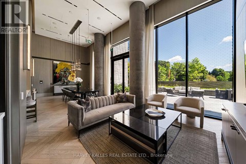 A modern living room with a glass table and a large window.