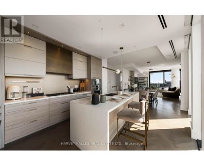 A modern kitchen with a large island and a dining area.