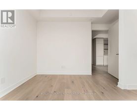 A spacious room with wooden flooring and white walls, part of a property by the Bosley - Toronto Realty Group Inc.