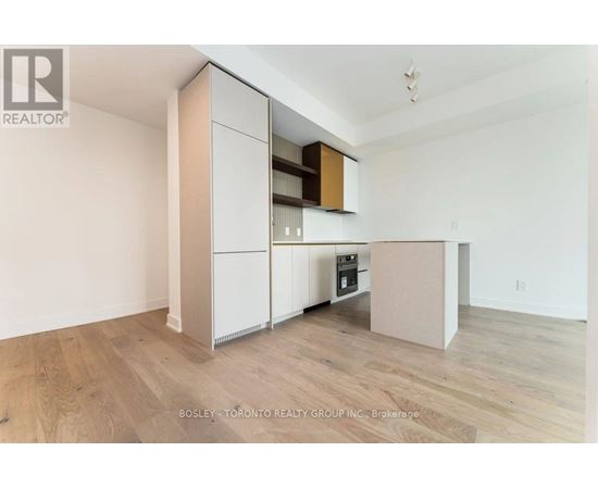 A kitchen with a white cabinet and wooden floors.