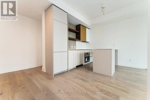 A kitchen with a white cabinet and wooden floors.
