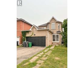 A house with a grey garage door and a brick wall.