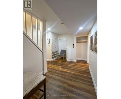 A hallway with wooden floors and white walls.