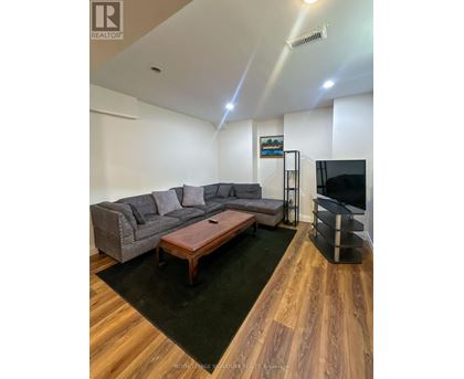 A living room with a grey couch and a wooden coffee table.
