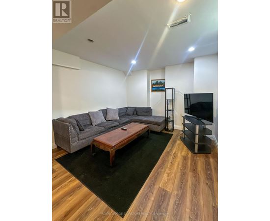A living room with a grey couch and a wooden coffee table.