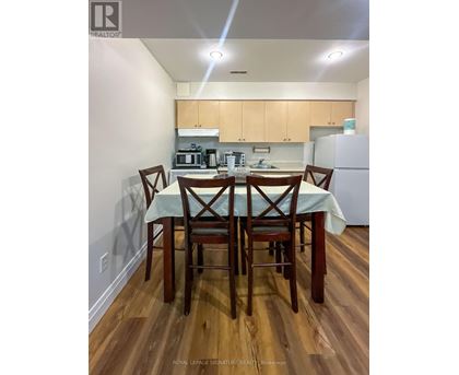 A kitchen with a table and chairs in the foreground.