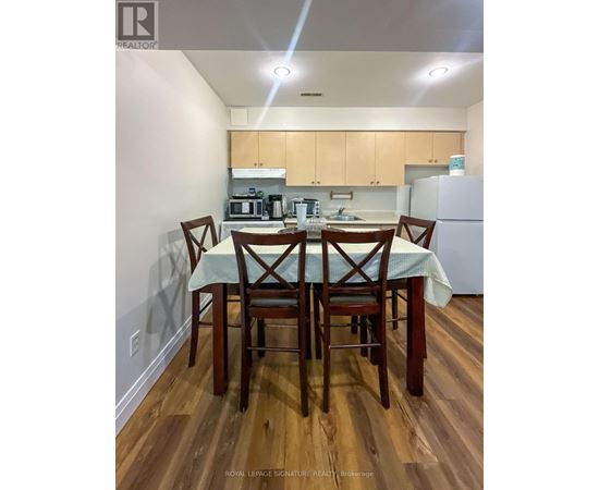 A kitchen with a table and chairs in the foreground.