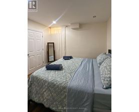 A bedroom with a bed, pillows, and a mirror.