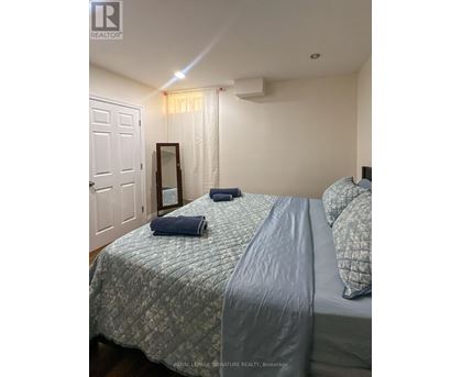 A bedroom with a bed, pillows, and a mirror.