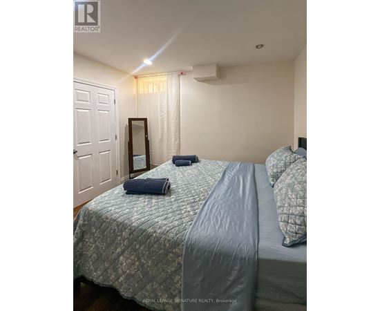 A bedroom with a bed, pillows, and a mirror.