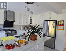 A kitchen with a refrigerator, stove, and sink.