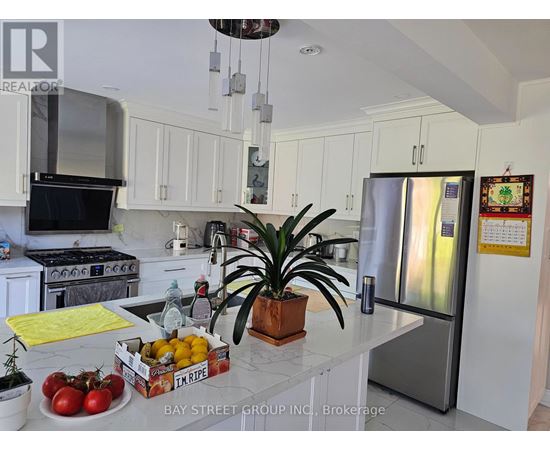 A kitchen with a refrigerator, stove, and sink.