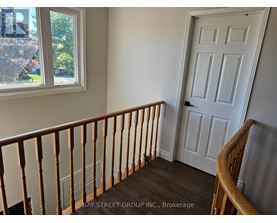 A white door is in a room with a window and a balcony.