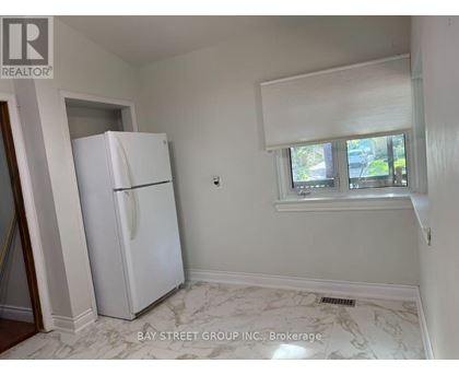 A white refrigerator in a kitchen with marble flooring.