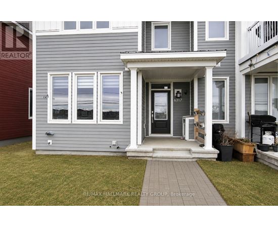 A grey house with a black door and windows.