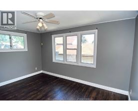 A room with a ceiling fan and a window with blinds.